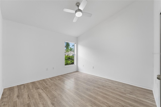 empty room with light wood-type flooring, vaulted ceiling, baseboards, and ceiling fan