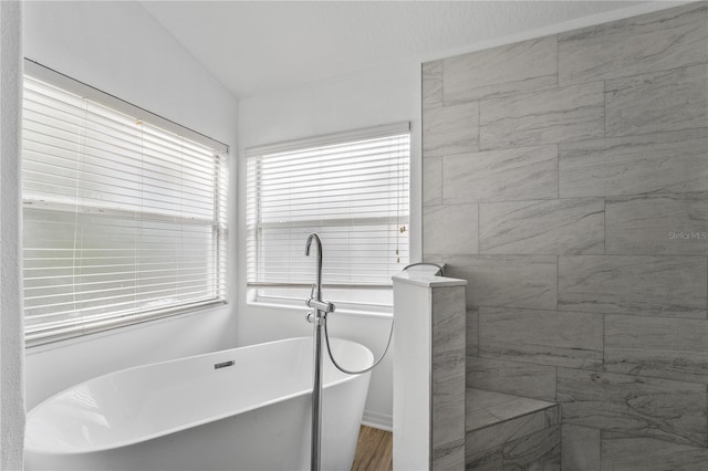 full bath with a soaking tub and a tile shower