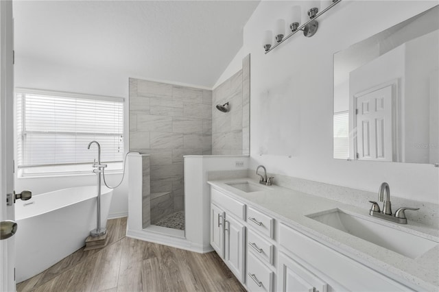 bathroom featuring vaulted ceiling, a walk in shower, a sink, and wood finished floors