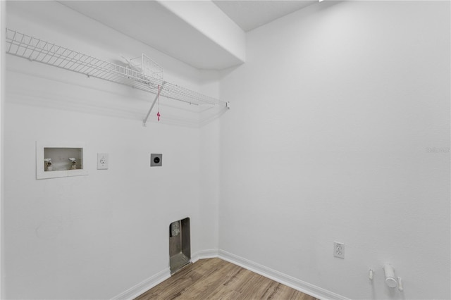 clothes washing area featuring hookup for a gas dryer, hookup for an electric dryer, washer hookup, wood finished floors, and baseboards