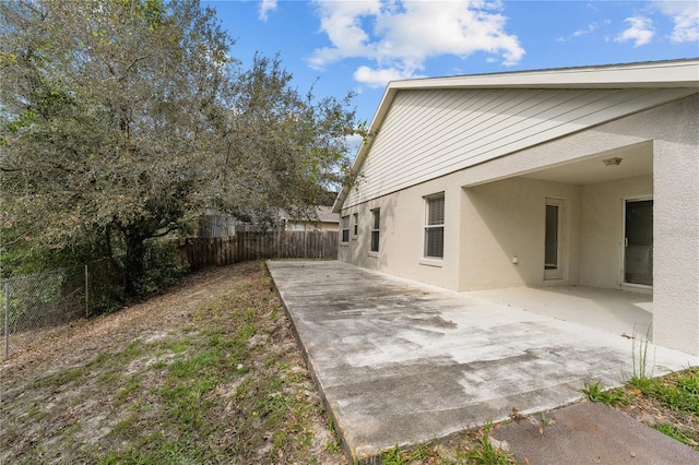 exterior space featuring a patio area, a fenced backyard, and stucco siding