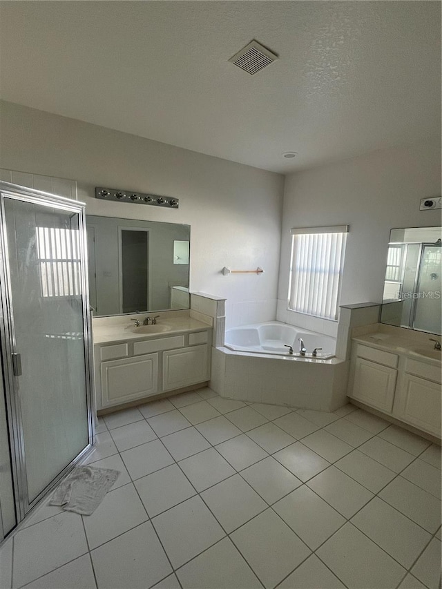 bathroom with a garden tub, two vanities, visible vents, and a shower stall