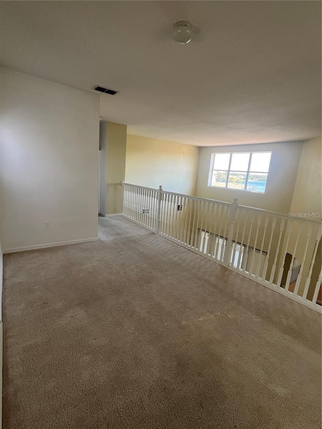 unfurnished room with visible vents and carpet