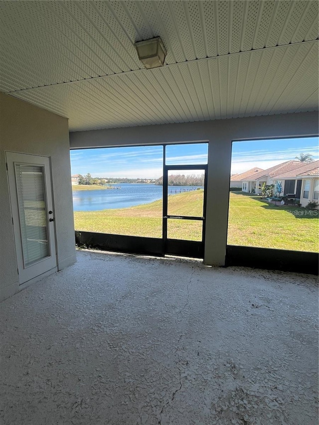 unfurnished sunroom featuring a water view