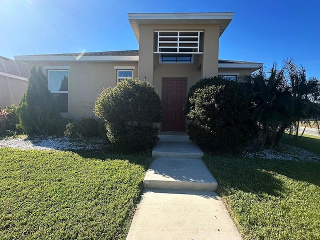 view of front facade featuring a front yard and stucco siding