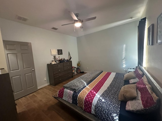 bedroom with baseboards, wood finished floors, visible vents, and a ceiling fan