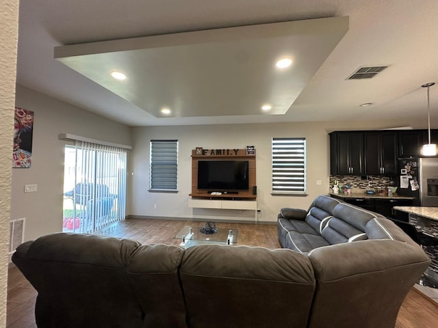 living room featuring baseboards, wood finished floors, visible vents, and recessed lighting