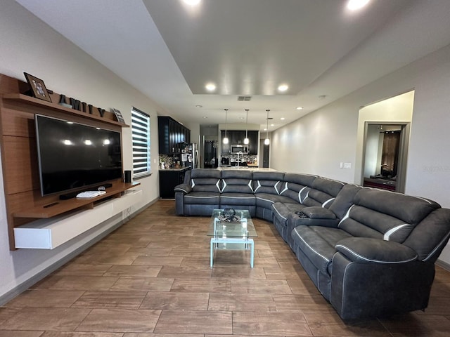 living room with baseboards, visible vents, and recessed lighting