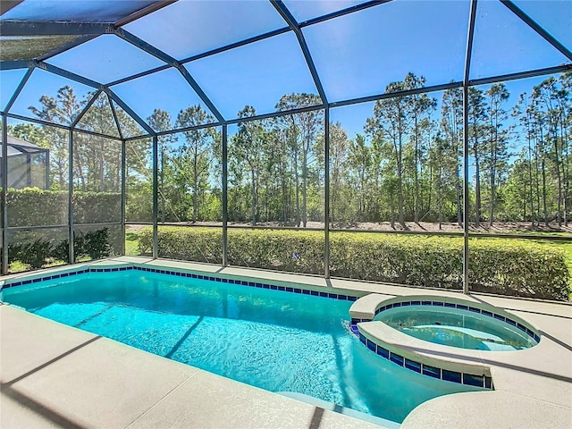 view of pool featuring a pool with connected hot tub, glass enclosure, and a patio