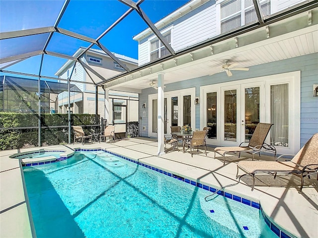 view of swimming pool with glass enclosure, a pool with connected hot tub, a ceiling fan, french doors, and a patio area