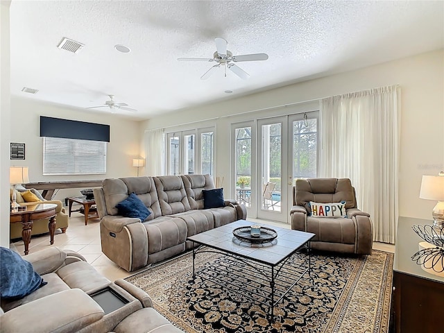 living room with french doors, visible vents, a textured ceiling, and tile patterned floors