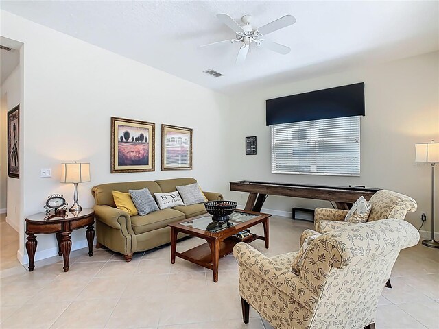 living area featuring baseboards, visible vents, a ceiling fan, and light tile patterned flooring