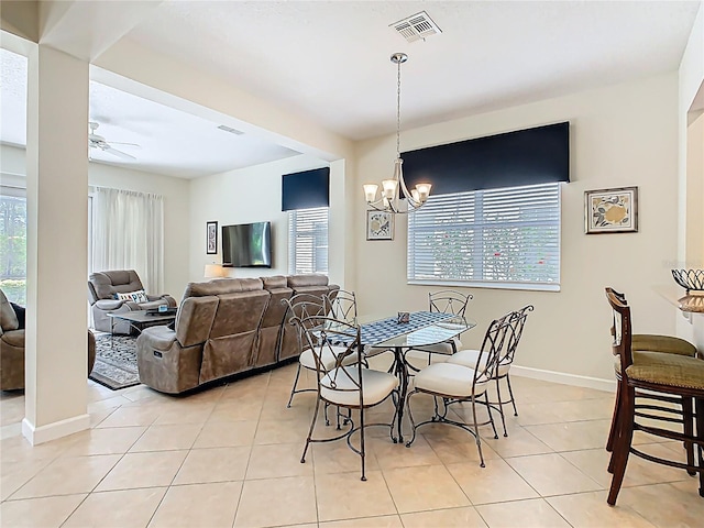 dining space featuring ceiling fan with notable chandelier, a wealth of natural light, light tile patterned flooring, and visible vents