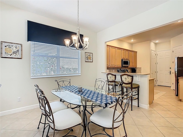 dining room featuring light tile patterned floors, baseboards, and an inviting chandelier