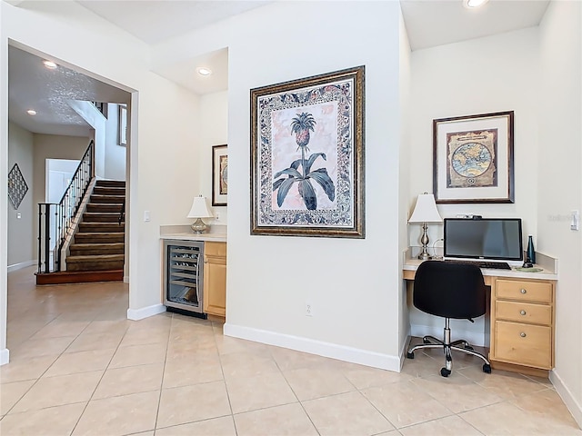 office space featuring wine cooler, light tile patterned flooring, and baseboards