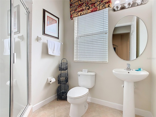 full bath featuring toilet, a sink, baseboards, a shower stall, and tile patterned floors