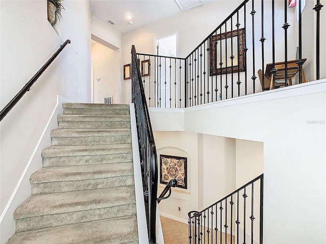 staircase featuring baseboards and visible vents