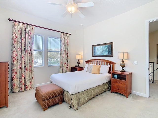 carpeted bedroom with ceiling fan and baseboards