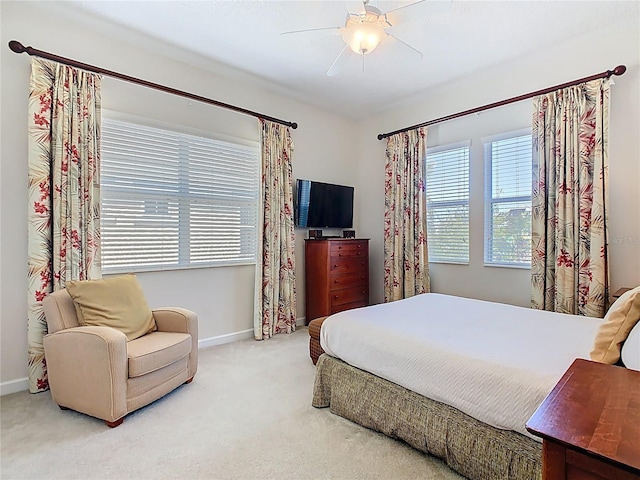 carpeted bedroom featuring ceiling fan, multiple windows, and baseboards