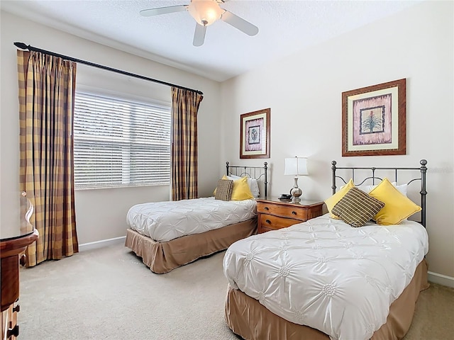 carpeted bedroom with baseboards and a ceiling fan