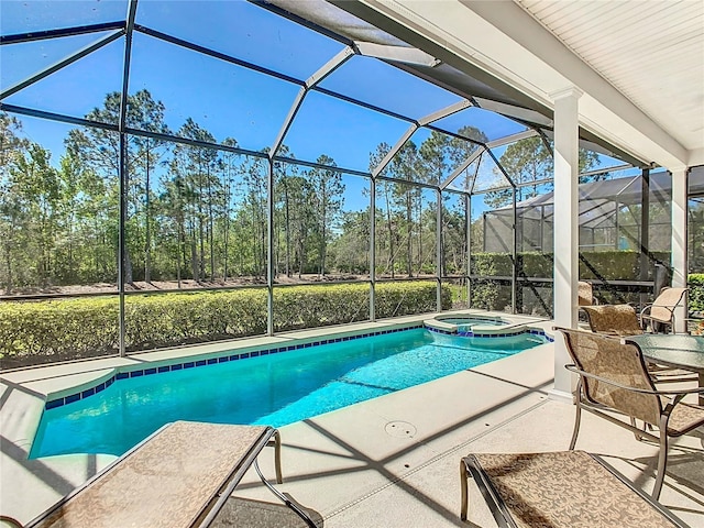 view of pool featuring glass enclosure, a patio, and a pool with connected hot tub