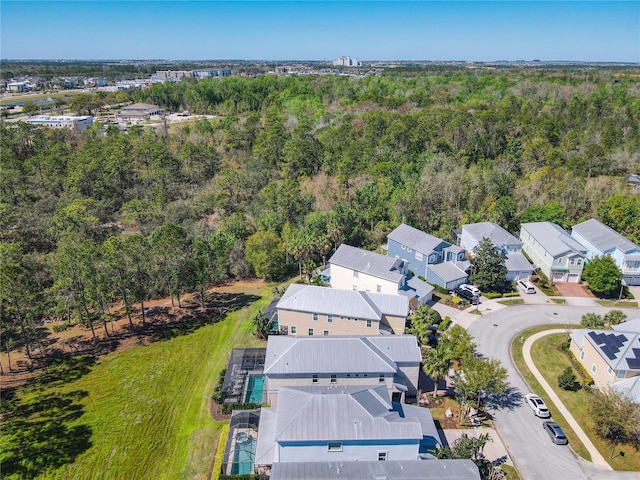 drone / aerial view featuring a residential view and a view of trees