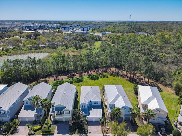 drone / aerial view featuring a residential view and a wooded view