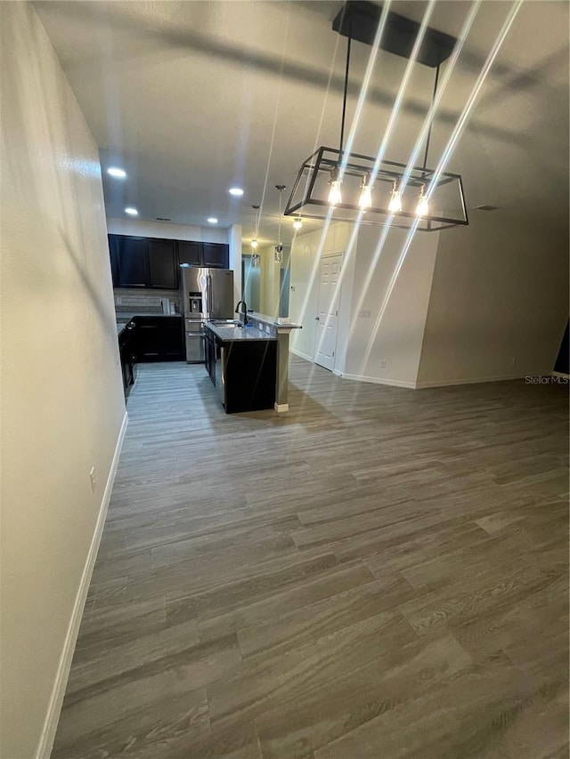 kitchen featuring a sink, a center island with sink, open floor plan, and dark wood finished floors