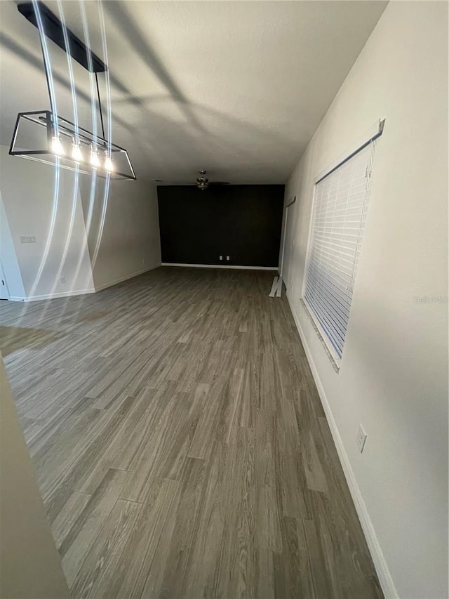 unfurnished living room featuring baseboards and wood finished floors