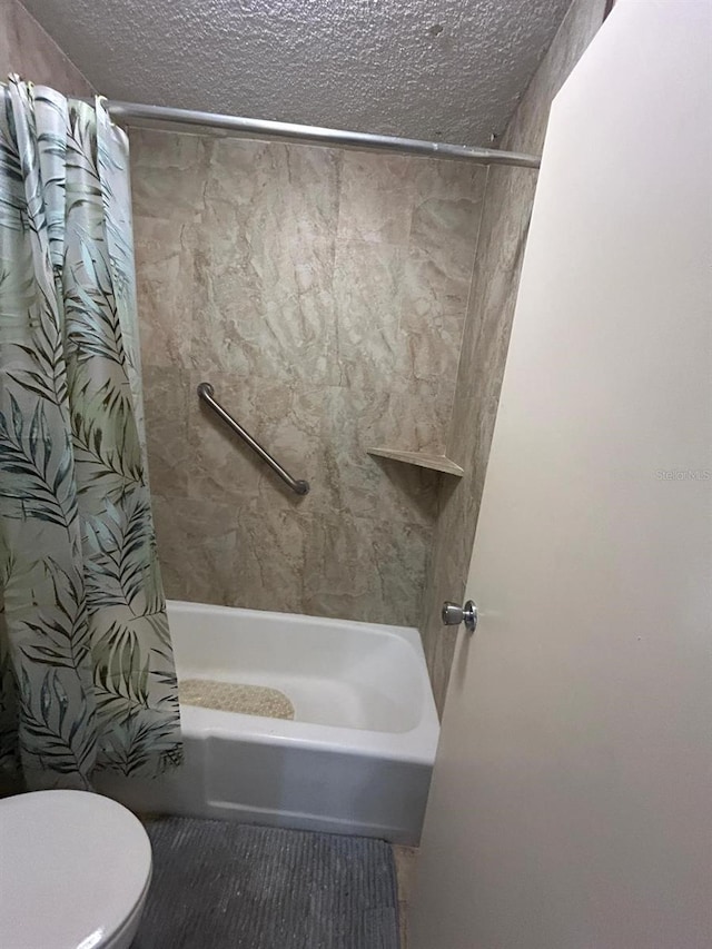 full bathroom featuring toilet, shower / tub combo, and a textured ceiling