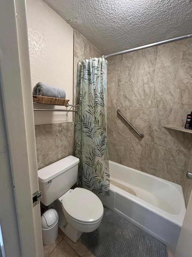 full bath featuring shower / bath combo, toilet, tile patterned flooring, a textured ceiling, and tile walls