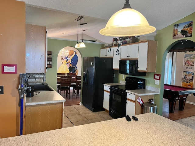 kitchen featuring a sink, arched walkways, black appliances, and light tile patterned flooring