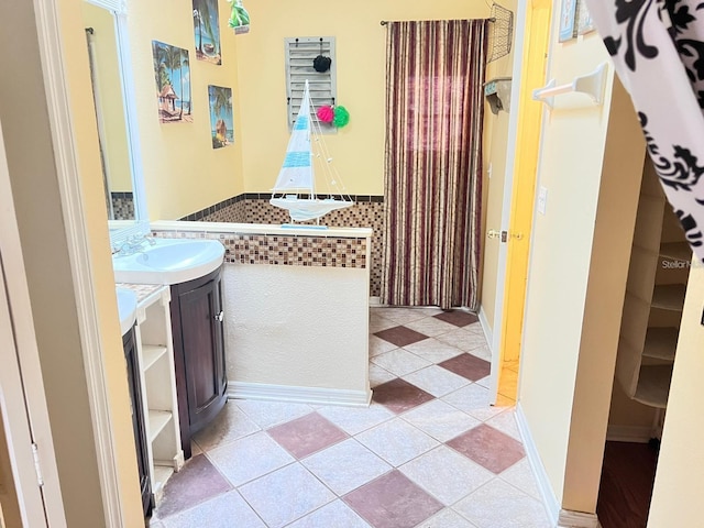 bathroom with vanity, tile patterned floors, and wainscoting