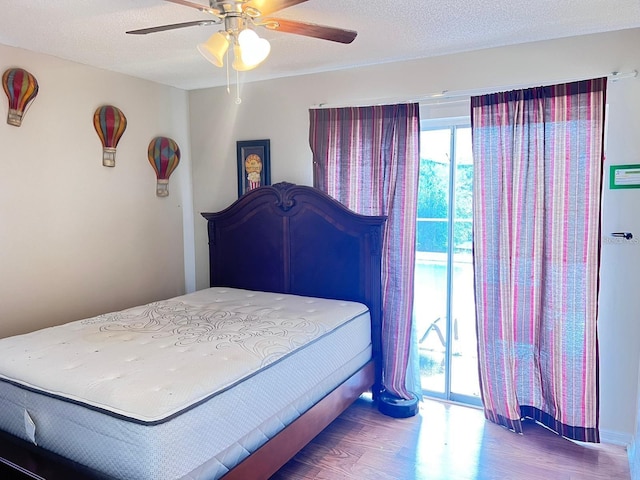 bedroom featuring a textured ceiling, a ceiling fan, and wood finished floors