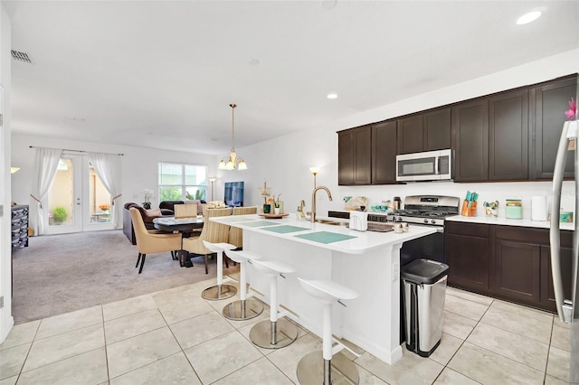 kitchen featuring visible vents, stainless steel appliances, light countertops, light tile patterned floors, and light colored carpet