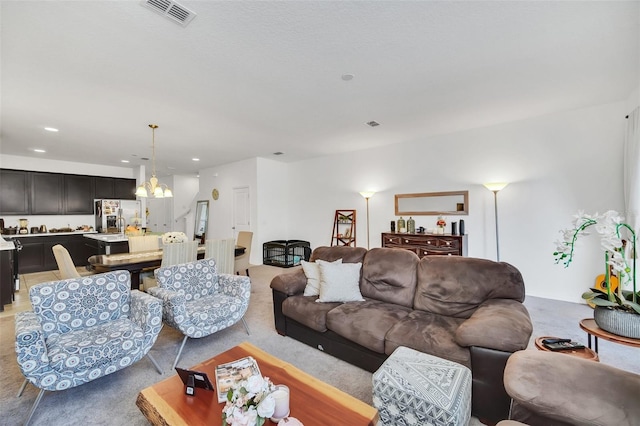 living area featuring light carpet, recessed lighting, visible vents, and a chandelier