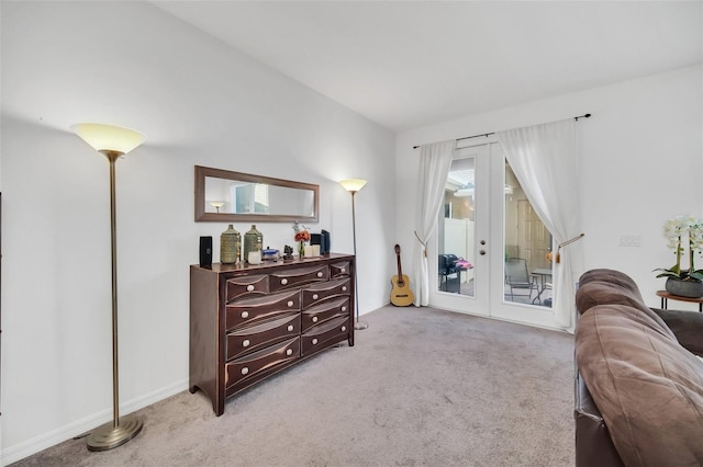 sitting room with french doors, carpet flooring, and vaulted ceiling