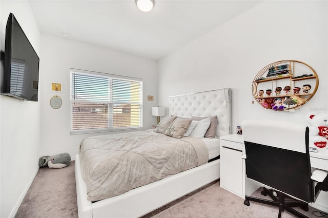 bedroom with light carpet and baseboards