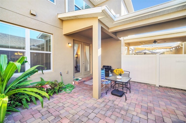 view of patio featuring french doors, outdoor dining area, and fence