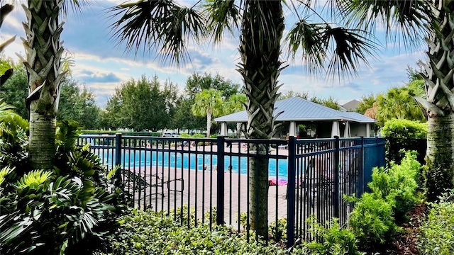 community pool with a gazebo and fence