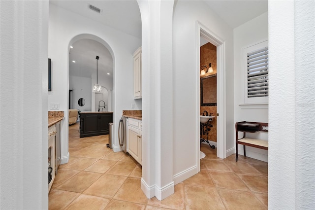 full bath featuring visible vents, vanity, washer / dryer, tile patterned flooring, and baseboards