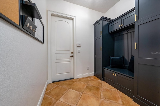 mudroom with light tile patterned floors and baseboards