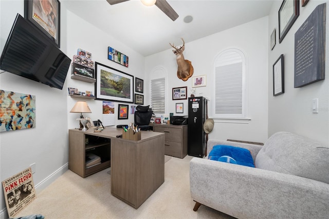 office featuring light carpet, a ceiling fan, and baseboards