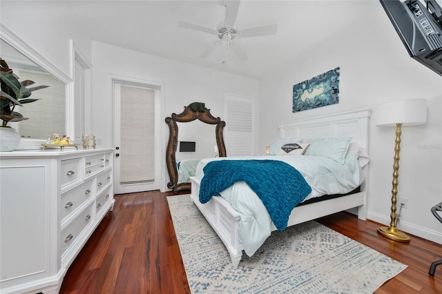 bedroom with ceiling fan, dark wood finished floors, and baseboards