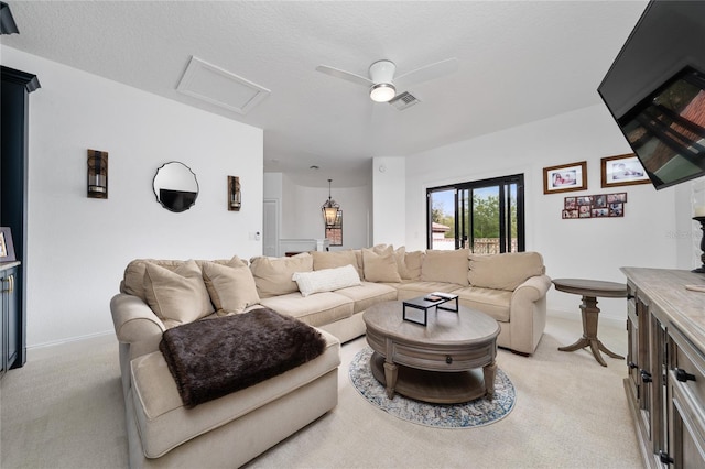 living area with visible vents, attic access, light carpet, ceiling fan, and baseboards