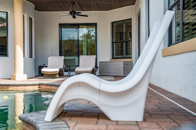 view of patio with an outdoor pool and a ceiling fan