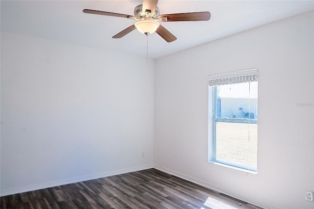 empty room with a ceiling fan, dark wood finished floors, and baseboards