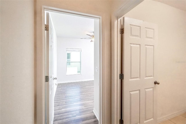 hallway with baseboards and wood finished floors