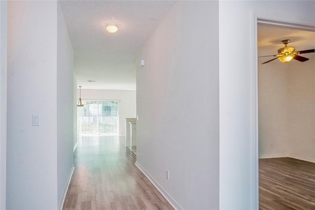 hallway featuring baseboards and wood finished floors