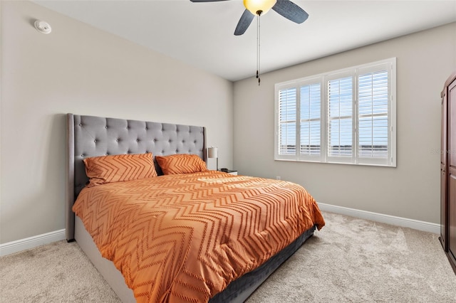 bedroom with light carpet, ceiling fan, and baseboards